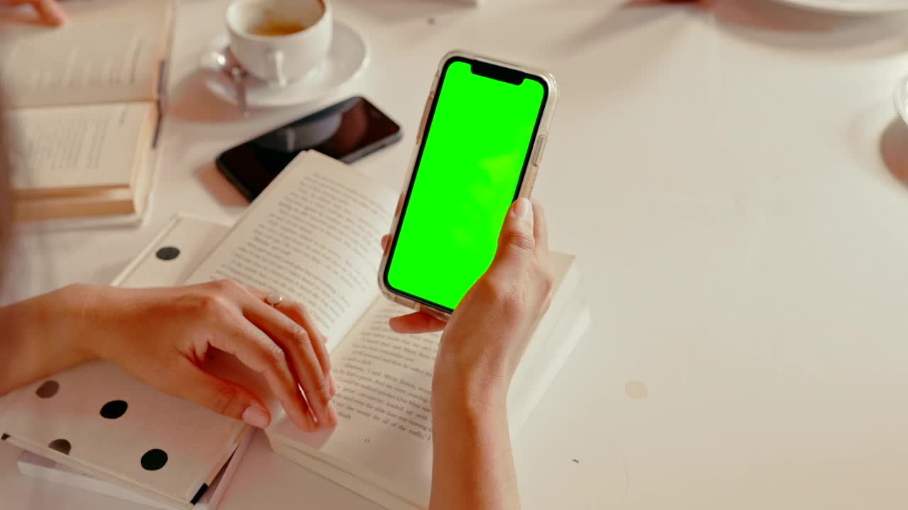 一段4k视频记录了一个陌生女人在咖啡馆看书时用手机的画面