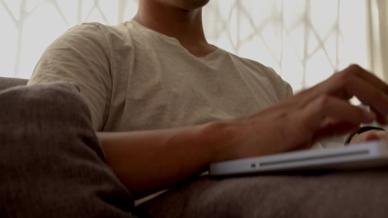 一个年轻人在家里用笔记本电脑的4k视频片段