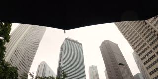 下雨天，撑着伞仰望摩天大楼