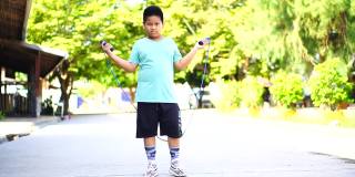 亚洲男孩跳绳锻炼，学校放假期间在学校锻炼阻止Covid-19