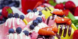 马卡龙，手工制作的精美甜品，用新鲜草莓和蓝莓装饰的巧克力甜点，精致的黄色和粉色蛋糕，糖和健康食品