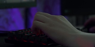 近景的专业网络运动玩家手中使用电脑键盘和鼠标。资料片。男手边玩电子游戏，概念休闲