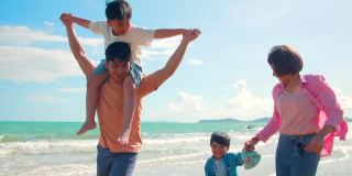 快乐的亚洲家庭在沙滩上奔跑
