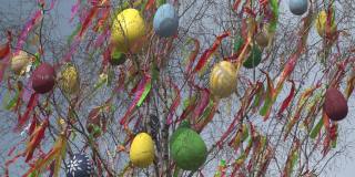 布拉格的一棵五颜六色的复活节树在刮风的日子里用一些巨大的复活节彩蛋和一些五颜六色的丝带装饰着。