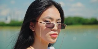 时尚年轻的黑发模特与完美的皮肤在太阳镜。美丽的亚洲女人在夏季旅行。