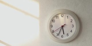现代的圆形时钟挂在旧水泥墙背景上，告诉时间在早上或晚上，家庭装饰，时间相关的物品在家里和学校和办公室，时钟指针