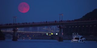 第聂伯河的夜景与移动的船只和照明人行桥。