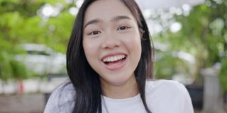 漂亮的亚洲少女谈论通过视频电话介绍自己快乐的微笑。漂亮的脸蛋和健康的牙齿。表达自己的自信。积极思考的感觉。