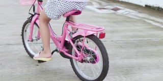 孩子们在夏天的柏油马路上骑自行车。