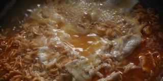 电饭锅里煮熟的速食面汤阴汤，肉片，鸡蛋，葱