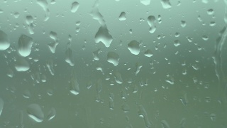 雨点滴在窗户上，顺着玻璃流下来。一个忧伤灰暗的秋天。视频素材模板下载