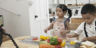 亚洲孩子在做饭和直播。