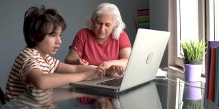 老奶奶和孙子在家里使用笔记本电脑