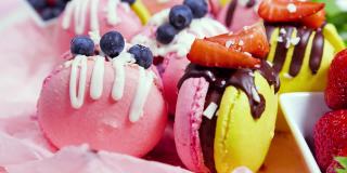 马卡龙手工制作的精美甜品，用新鲜草莓和蓝莓装饰的巧克力甜点，精致的黄色和粉色蛋糕，糖和健康食品