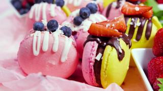 马卡龙手工制作的精美甜品，用新鲜草莓和蓝莓装饰的巧克力甜点，精致的黄色和粉色蛋糕，糖和健康食品视频素材模板下载