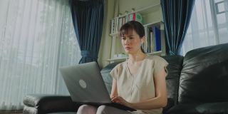 亚洲女企业家因新冠肺炎疫情在家办公，对电脑上的许多工作项目感到厌倦。忙碌的女性自由职业女孩靠在沙发上得到休息和休息的健康