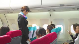 美丽的亚洲空姐或空中小姐在飞机起飞前走在过道上关闭行李舱并检查乘客。飞机客舱机组人员安全检查程序。视频素材模板下载