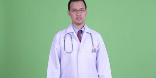 工作室肖像悲伤的亚洲人医生在绿色背景