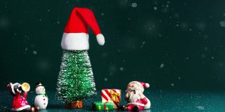 圣诞快乐，新年快乐的雪花飘落与圣诞树和圣诞老人，雪人和礼物盒在深绿色的背景。复制用于添加文本的空间