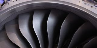 现代涡扇发动机。飞机的涡轮喷气发动机在黑色背景上的特写。飞机的涡扇发动机的叶片