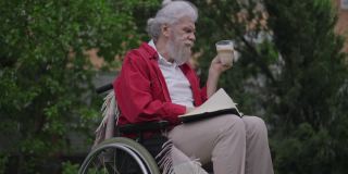 留着大胡子的白人残疾老人喝着卡布奇诺在户外用笔写日记。残疾的老年男性退休人员在后院的花园里喝咖啡，用慢动作书写思想。