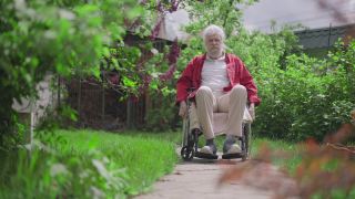 快乐的残障老人在阳光明媚的夏日花园中坐轮椅微笑。宽镜头自信积极的白种老年男性退休享受户外休闲。残疾和生活方式。视频素材模板下载