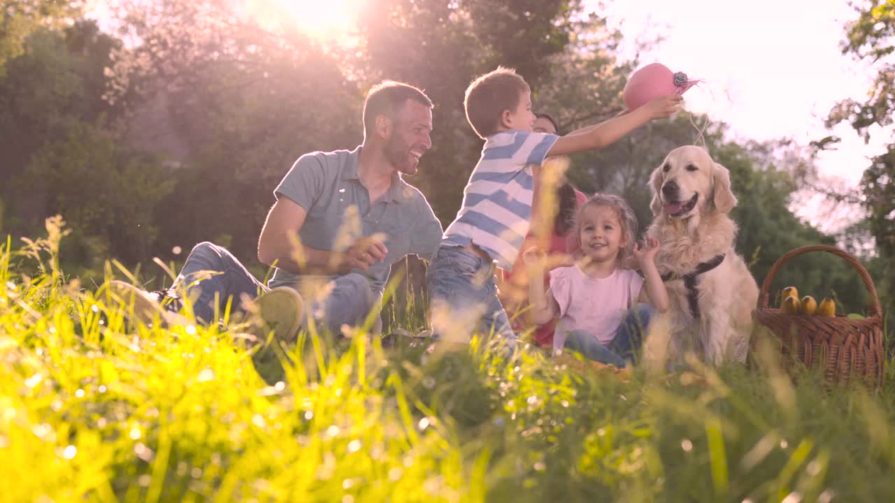幸福的家庭和狗在大自然中度过美好时光。