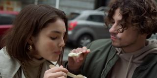 一对可爱的夫妇在街上吃冰淇淋。情侣户外约会。