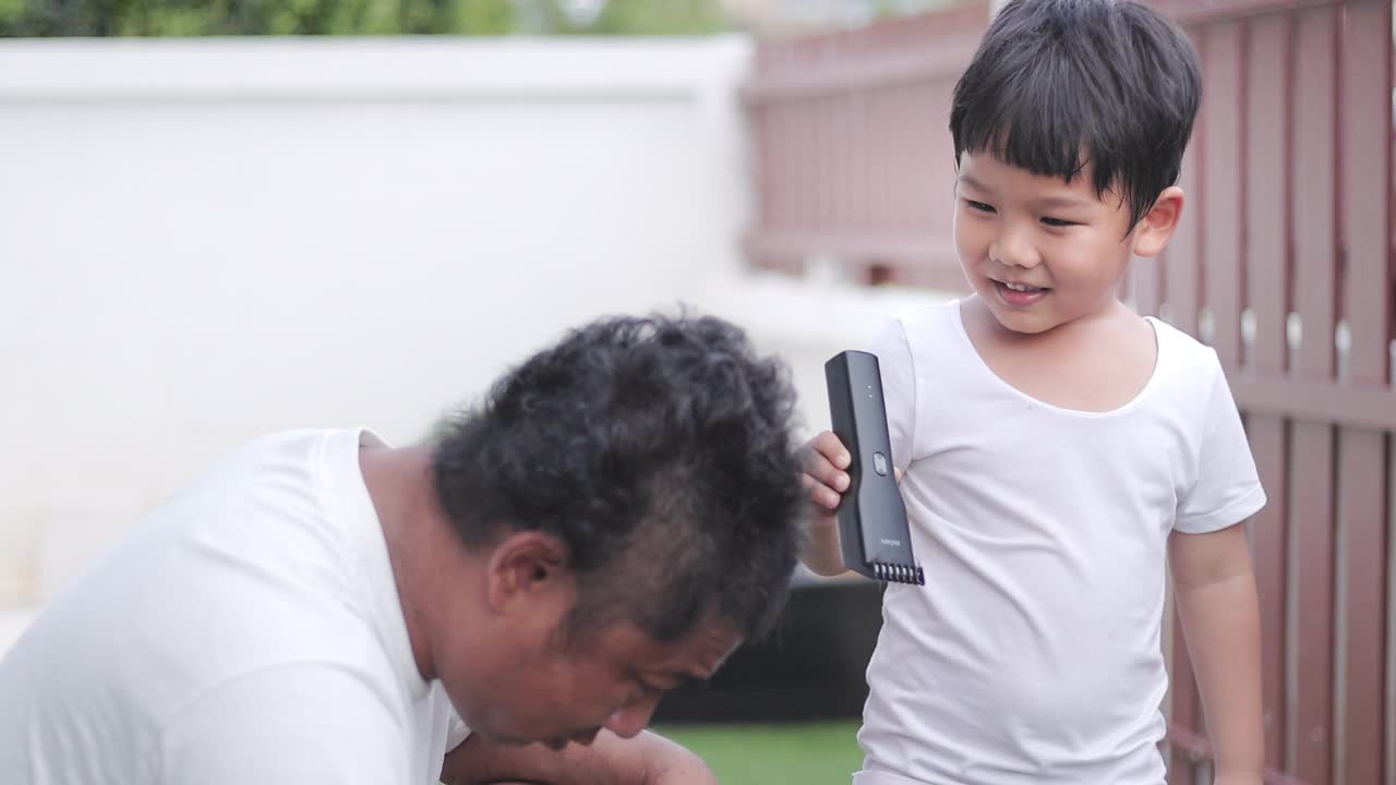 新冠肺炎大流行期间，儿子在家用电动剃须刀给父亲理发