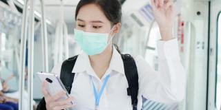 亚洲职业女性乘坐交通/轻轨时戴口罩预防新冠病毒。在新冠肺炎疫情情况下，外出工作时要注意。保持社交距离是为了安全