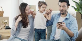 一家人和女儿一起跳舞唱歌，搬到新家时和孩子一起用智能手机，慢动作，4K分辨率。