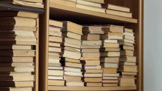 书架上有旧书。一位女士正在图书馆的书架上找书。人类选择书籍。白种人用手触摸书架上的书。阅读与教育的概念视频素材模板下载