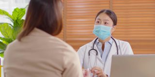 专业的亚洲女医生为患者提供健康咨询，为健康生活提供健康咨询，在医院穿着白大褂带着听诊器与患者交谈，医生和患者的概念