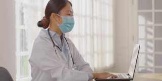 专业的亚洲女医生咨询孕妇，聪明的医生穿着白大褂，带着听诊器在医院与病人交谈，医生和孕妇的概念