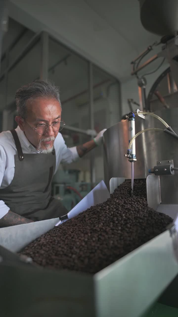 在他的工厂里，一名亚裔华裔高级技工正在检查烘培咖啡豆的去石过程