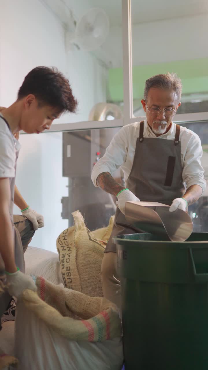 高级男子倒生咖啡豆在储存桶与勺子称重和混合