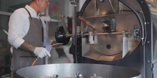 亚洲华人高级工作人员用手套刷牙，用真空吸尘器清洁咖啡烘焙机