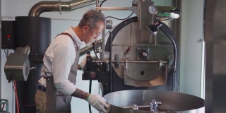一位亚洲华裔高级技工在他的工厂检查烘培咖啡豆的冷却过程