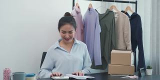 年轻的亚洲企业家在按目标销售服装时表现得兴高采烈。