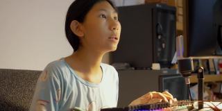 亚洲女孩晚上在家玩网络游戏直播，新潮的生活方式为新一代概念。