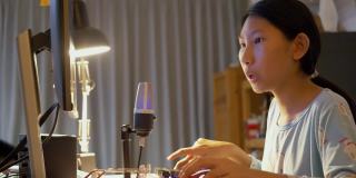 亚洲女孩晚上在家玩网络游戏直播，新潮的生活方式为新一代概念。