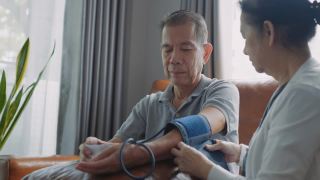 亚洲老年夫妇在家中测量血压。视频素材模板下载