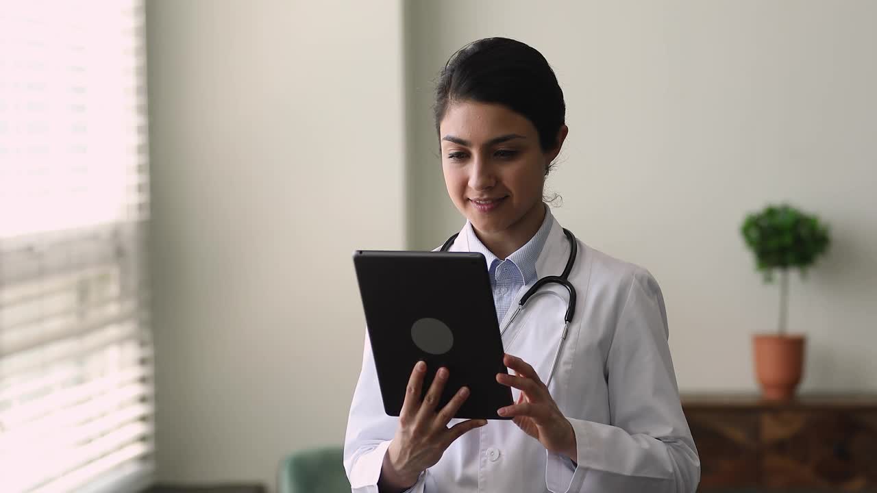 印度医生站在医院办公室使用平板电脑