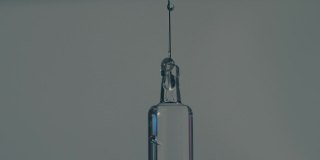 现代疫苗玻璃注射器的针头上滴下的药滴