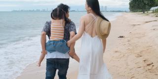 亚洲家庭与孩子在海滩散步快乐度假的概念