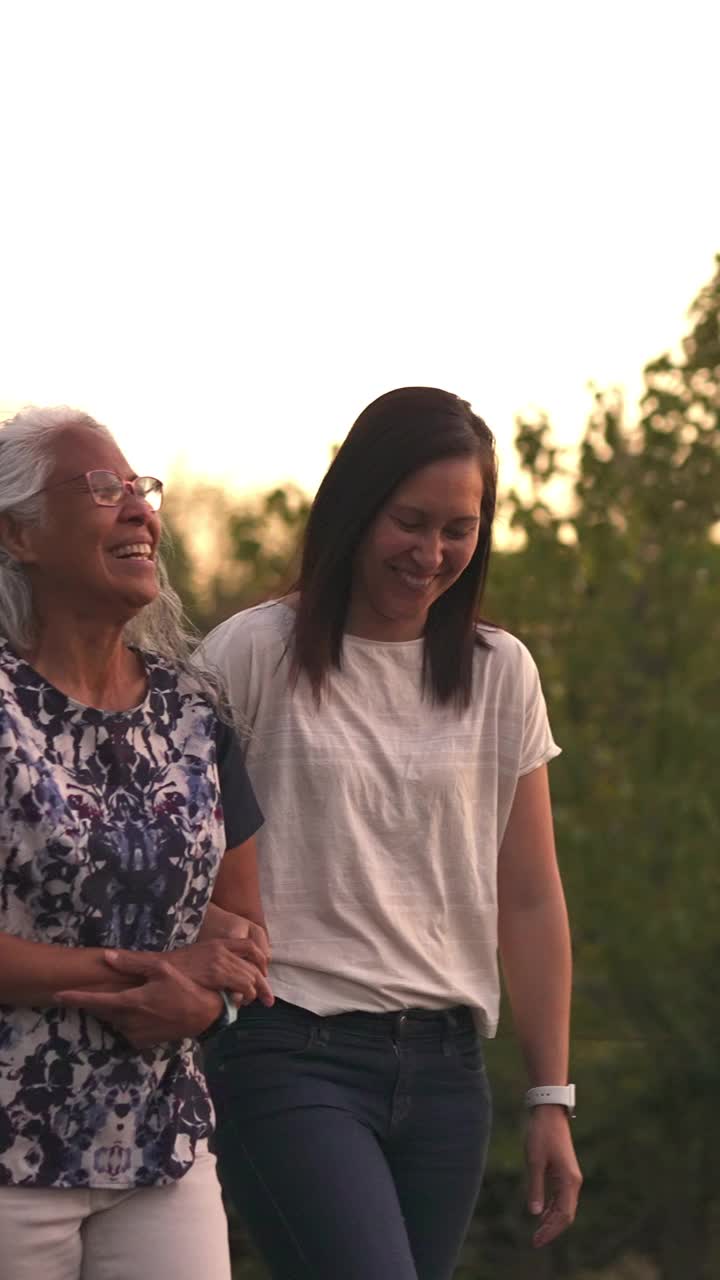 老年母亲与成年女儿散步的垂直视频