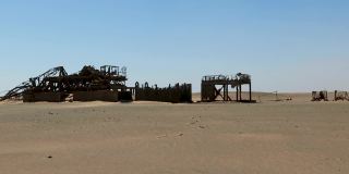 锈迹斑斑的大型石油钻井平台躺在沙漠里