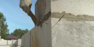 施工人员用抹刀将胶粘剂或溶液涂在墙体上。