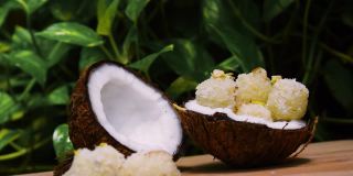 近距离拍摄的手采摘甜椰子球从椰子壳。传统印度甜品也被称为Kopra pak。