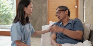 女医生在家检查亚洲老年男性患者的健康状况。